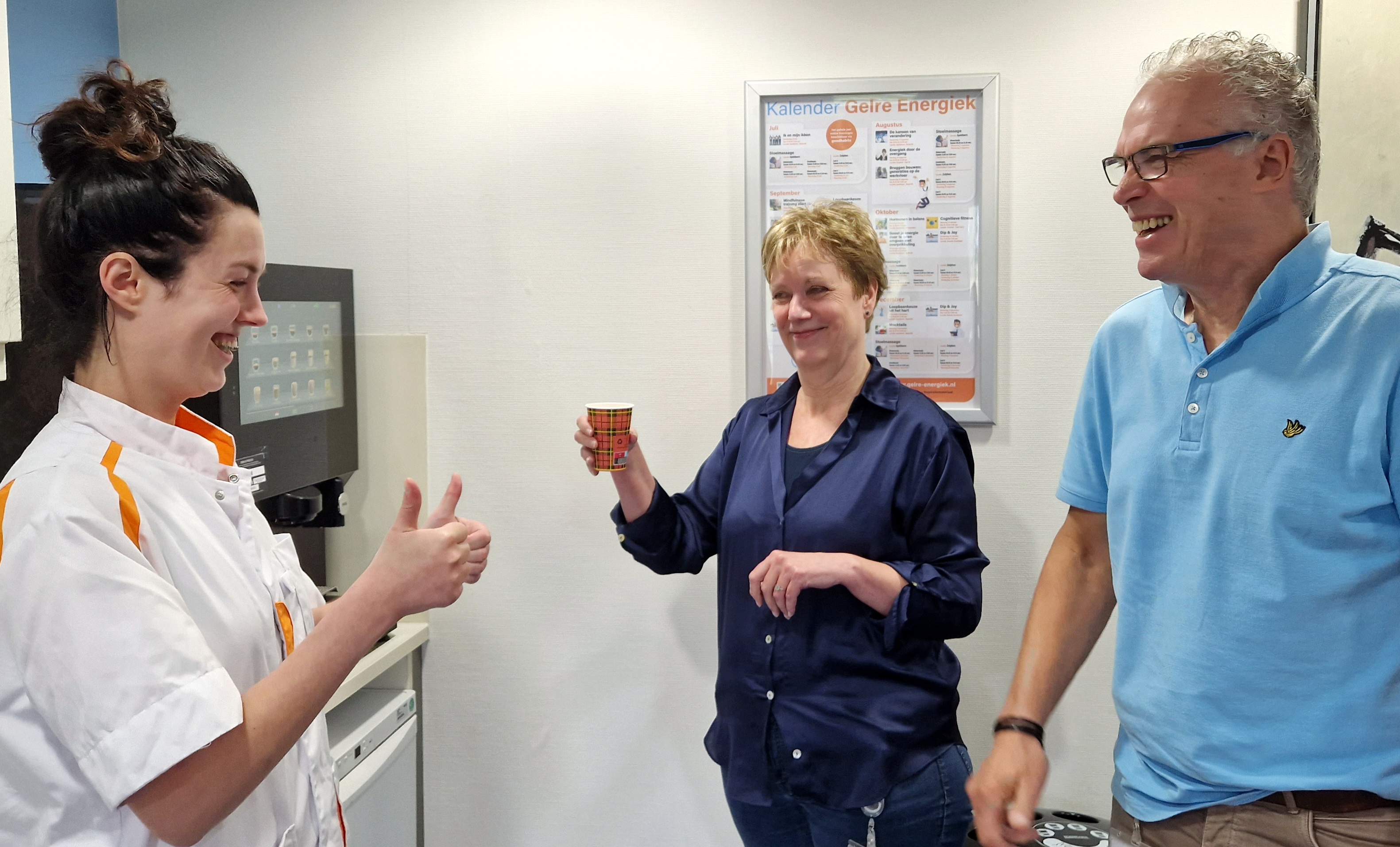 Chloë bij koffieautomaat met collega's